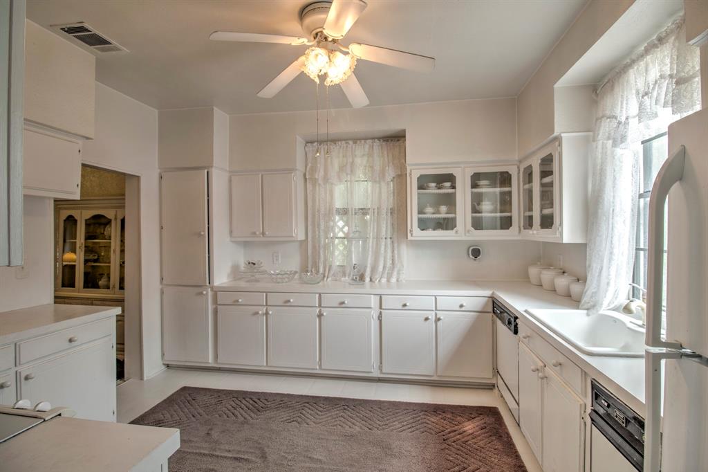 101 East Reed Trenton, TX 75490 - Photo 16 of 27 a large white kitchen with granite countertop a sink and dishwasher a stove with wooden floor