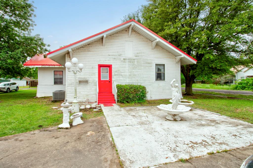 101 East Reed Trenton, TX 75490 - Photo 19 of 27 a front view of a house with a yard and garage