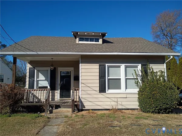 a front view of a house with a tree