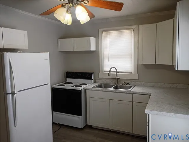 a kitchen with a sink a refrigerator a stove and a window