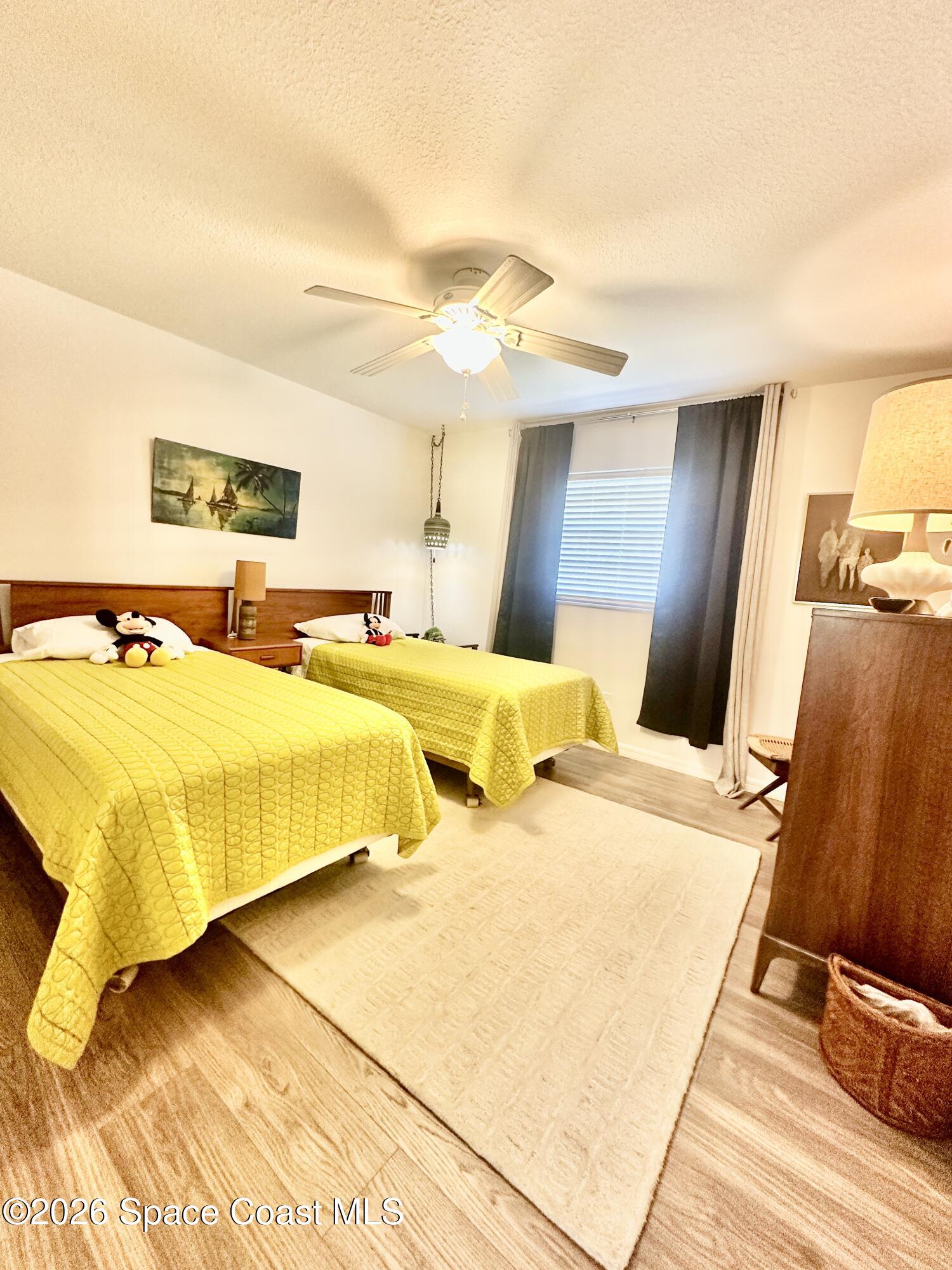 410 Surf Road Melbourne Beach, FL 32951 - Photo 18 of 29 a bedroom with a bed and wooden floor