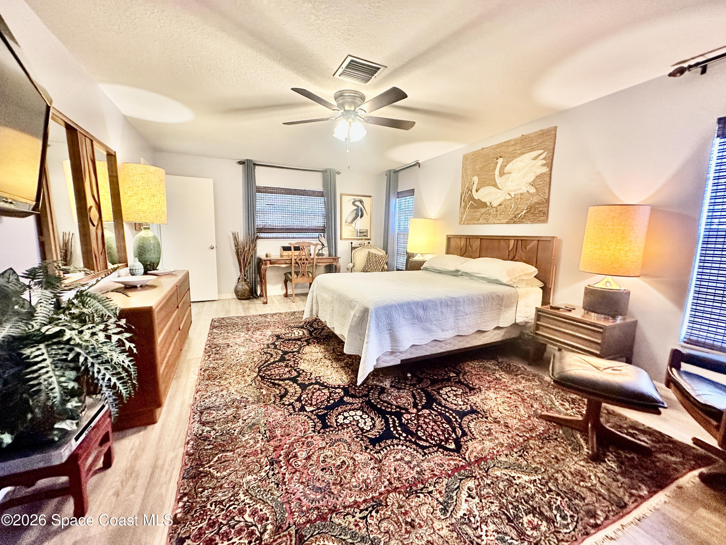 410 Surf Road Melbourne Beach, FL 32951 - Photo 20 of 29 a bedroom with a bed and wooden floor