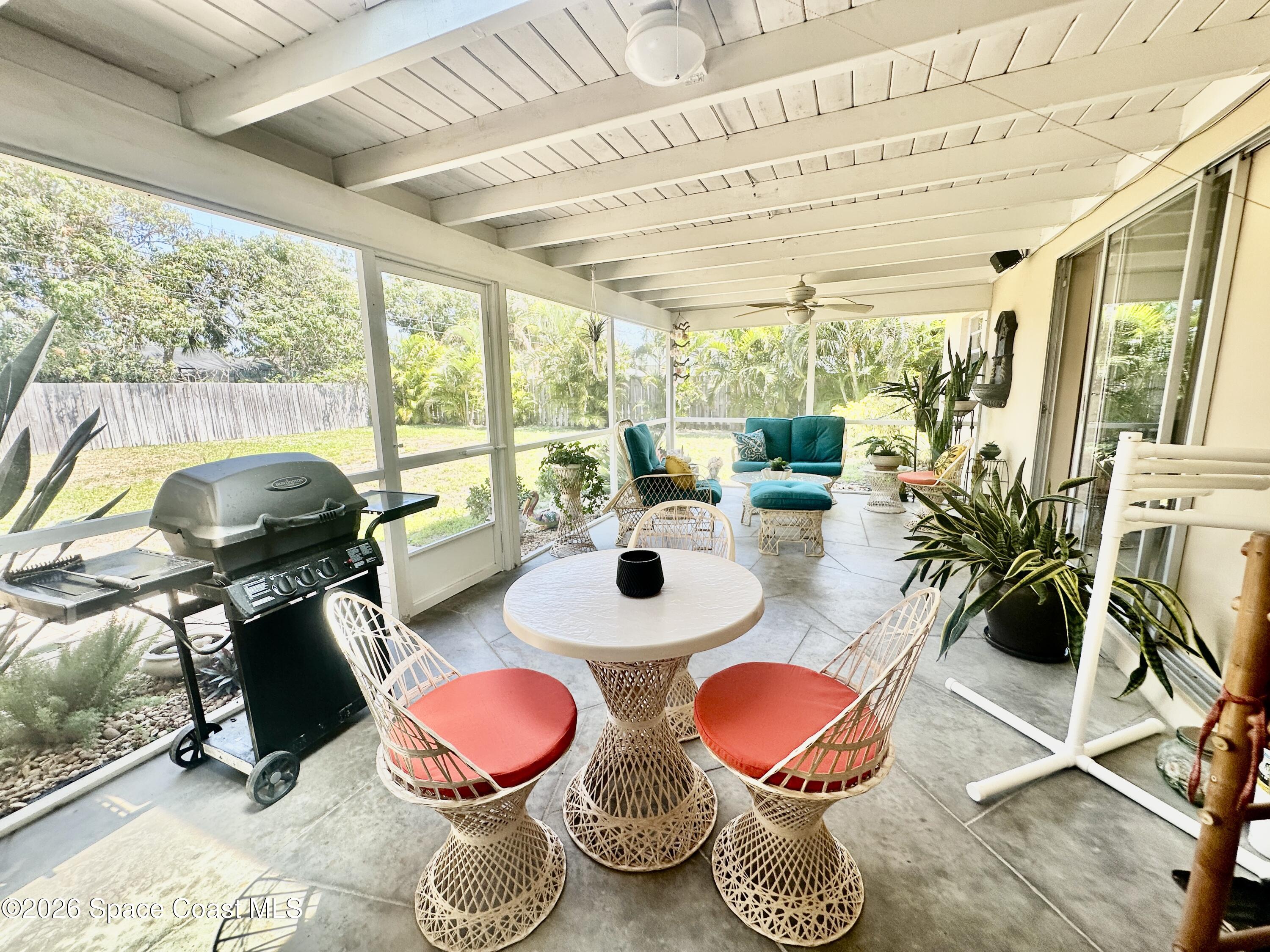 410 Surf Road Melbourne Beach, FL 32951 - Photo 25 of 29 a dining room with wooden floor and floor to ceiling windows
