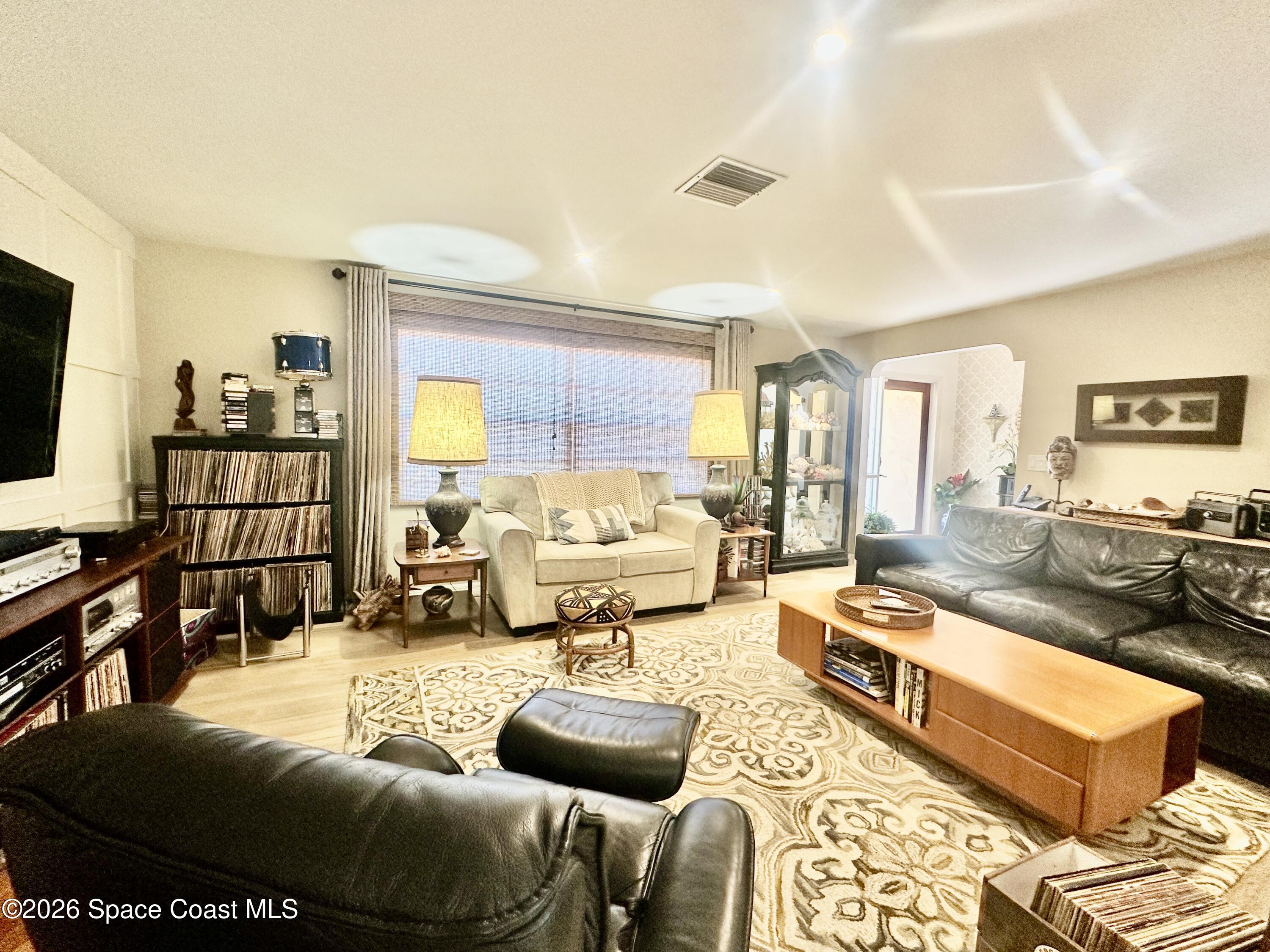 410 Surf Road Melbourne Beach, FL 32951 - Photo 4 of 29 a living room with furniture large window and a flat screen tv