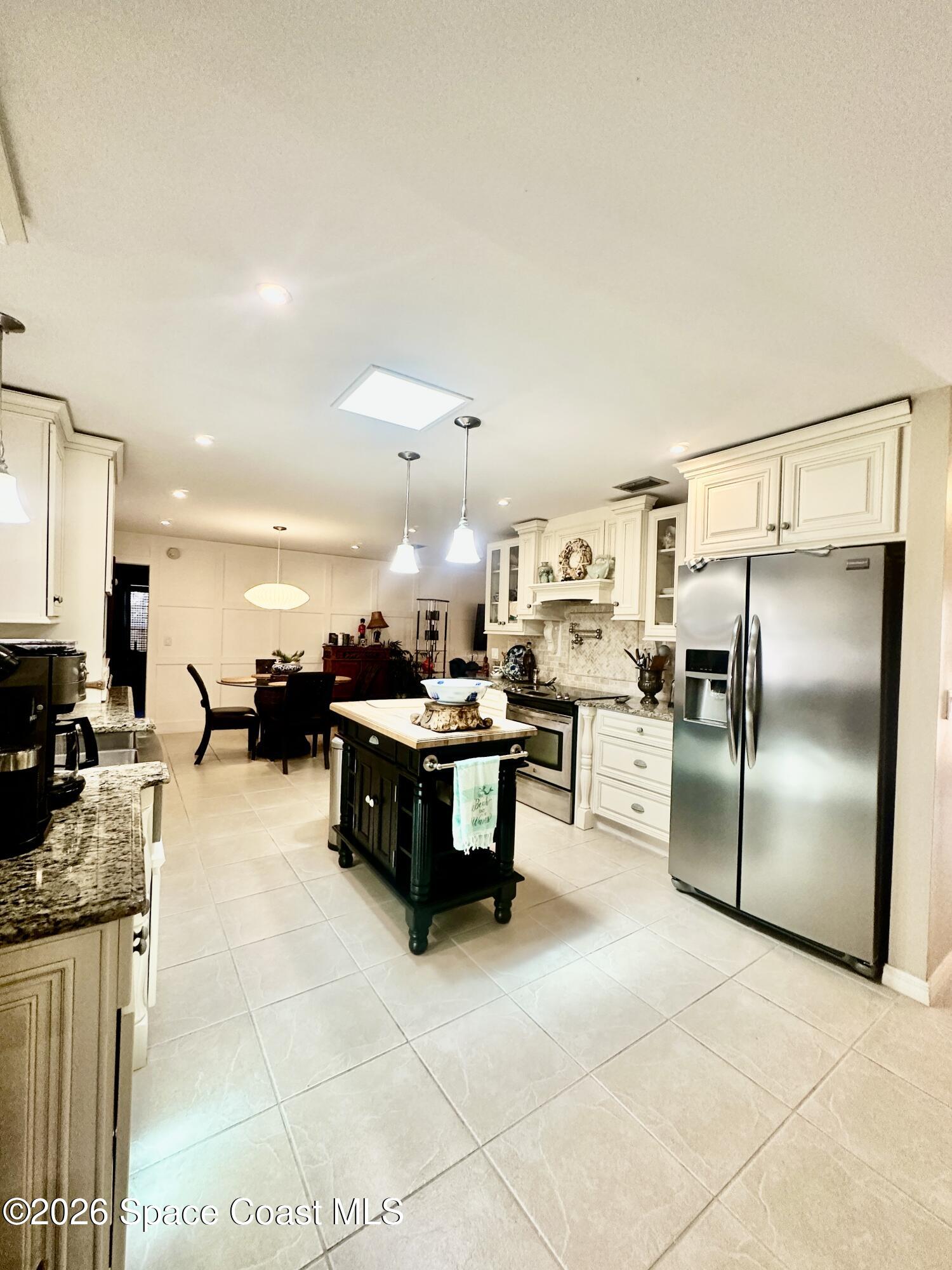 410 Surf Road Melbourne Beach, FL 32951 - Photo 8 of 29 a large kitchen with kitchen island granite countertop a large counter top cabinets and stainless steel appliances