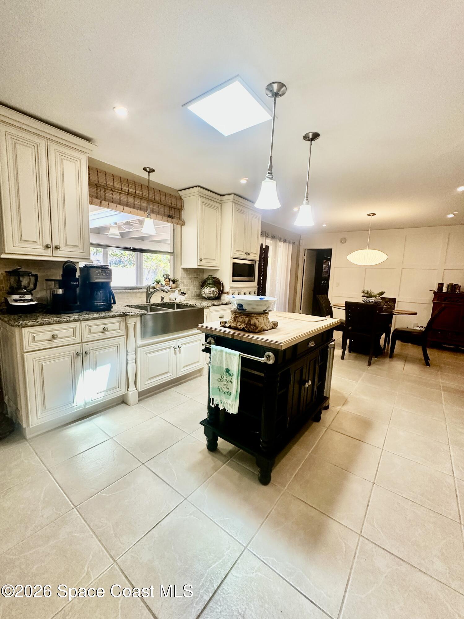 410 Surf Road Melbourne Beach, FL 32951 - Photo 9 of 29 a large kitchen with kitchen island granite countertop a stove a sink a counter top space and cabinets