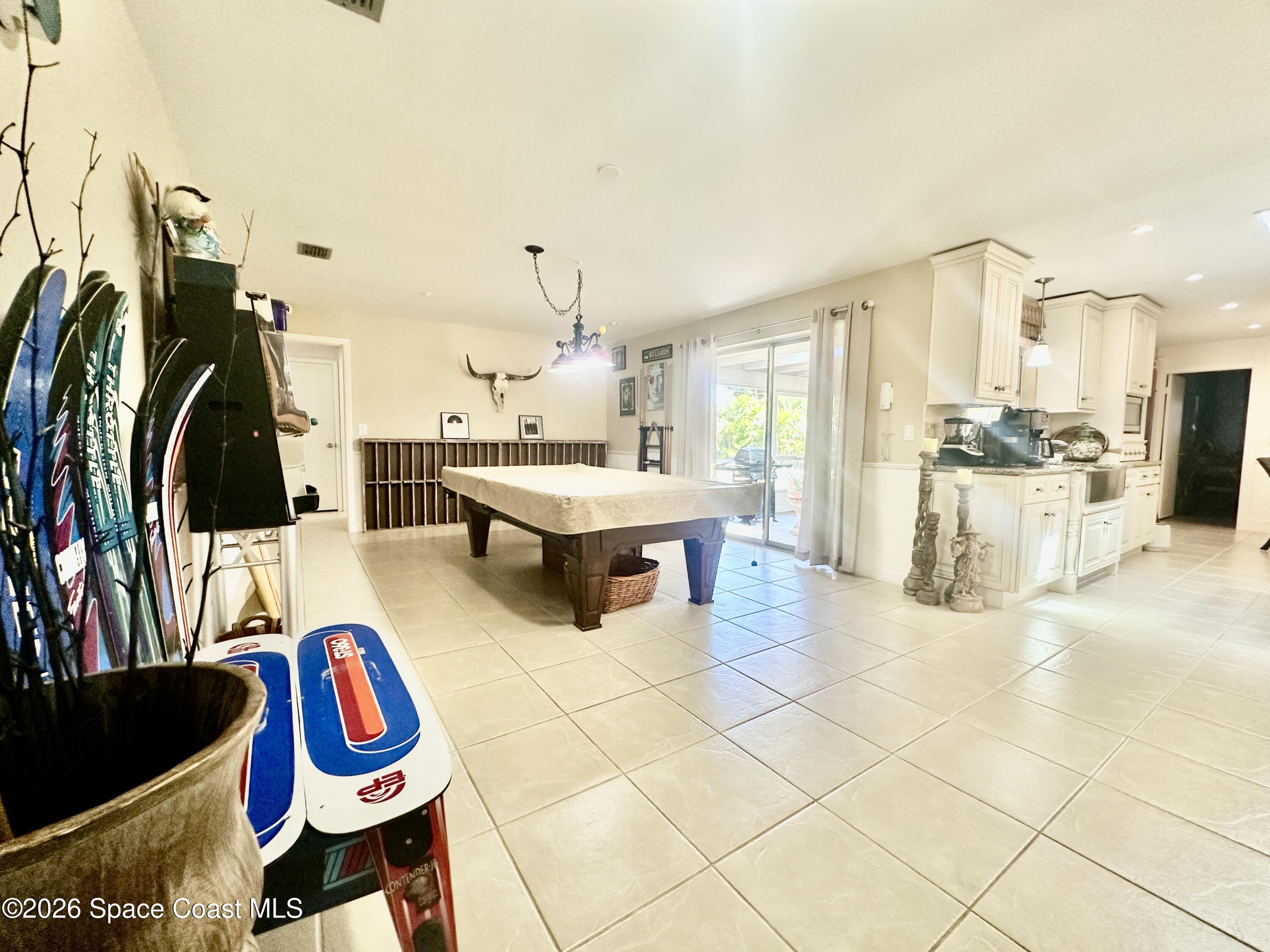 410 Surf Road Melbourne Beach, FL 32951 - Photo 10 of 29 a living room with patio furniture and a chandelier