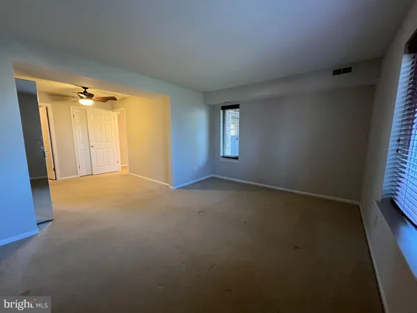 an empty room with windows and closet
