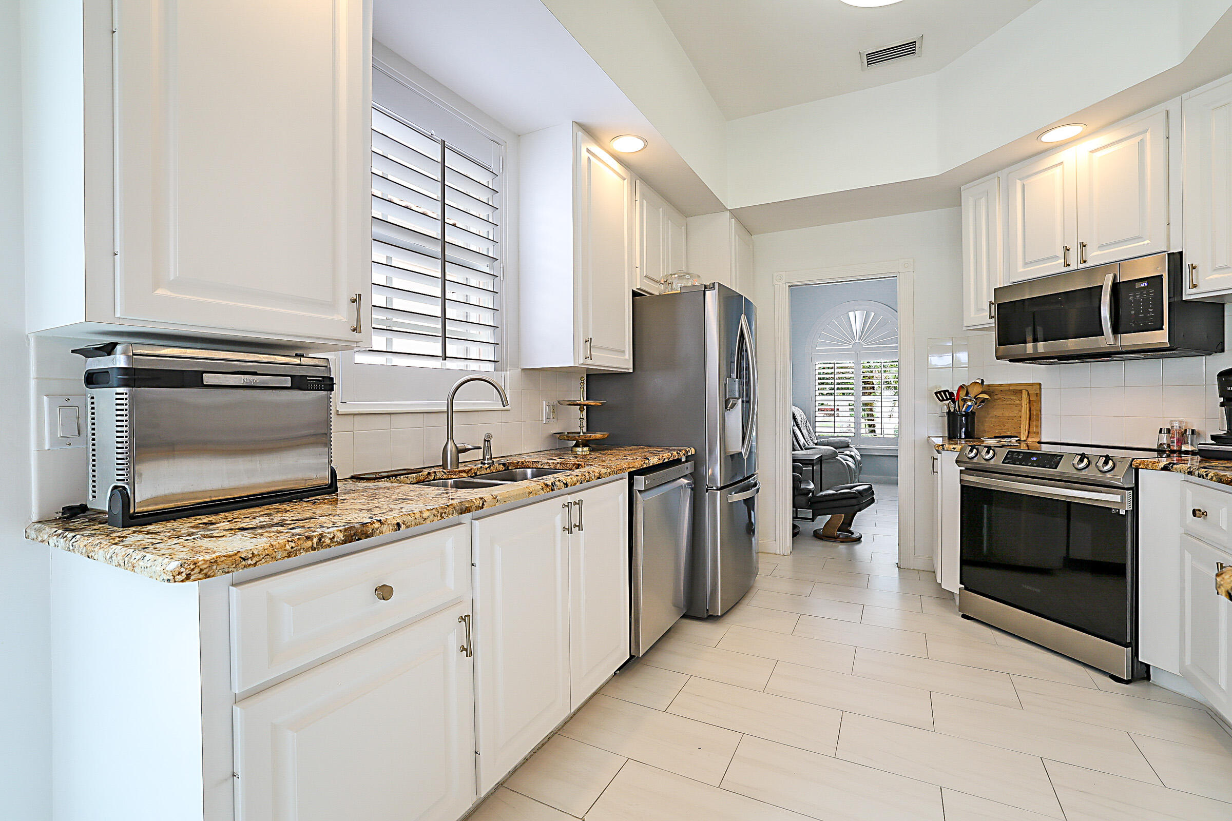 9520 Southwest Wedgewood Lane Stuart, FL 34997 - Photo 15 of 53 a kitchen with stainless steel appliances a stove sink and microwave