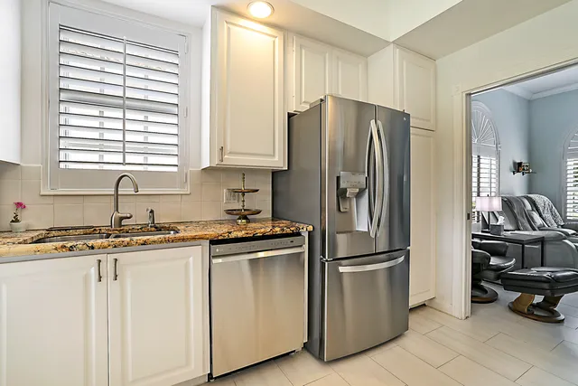 a kitchen with stainless steel appliances granite countertop a refrigerator and a sink