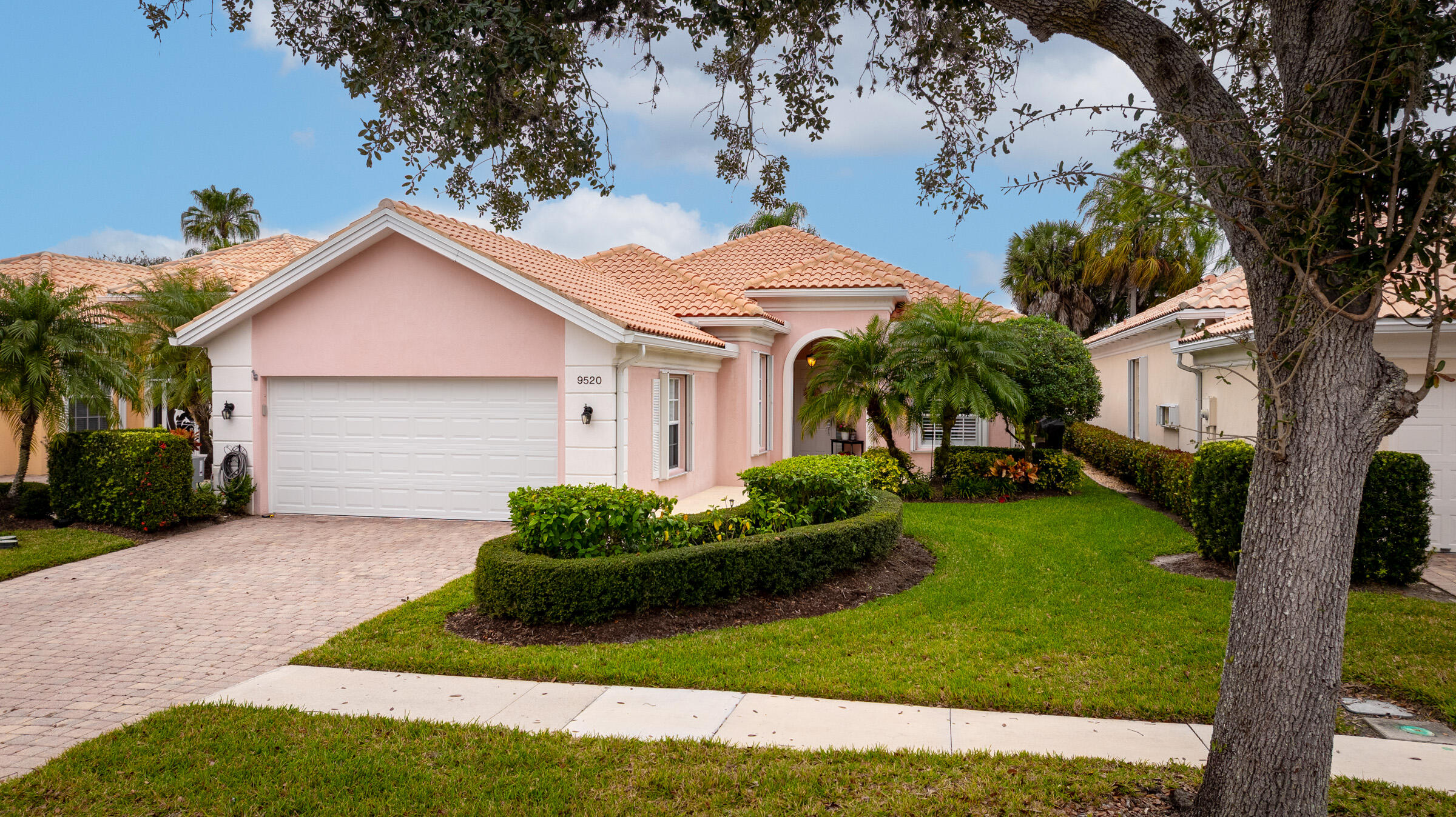9520 Southwest Wedgewood Lane Stuart, FL 34997 - Photo 2 of 53 a front view of a house with a garden and plants