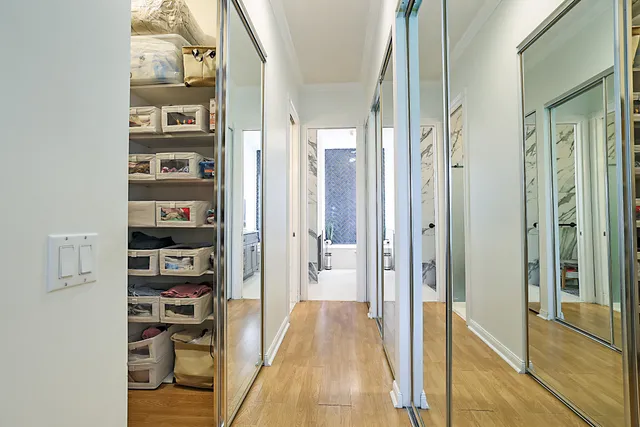 a view of a hallway with wooden floor and windows