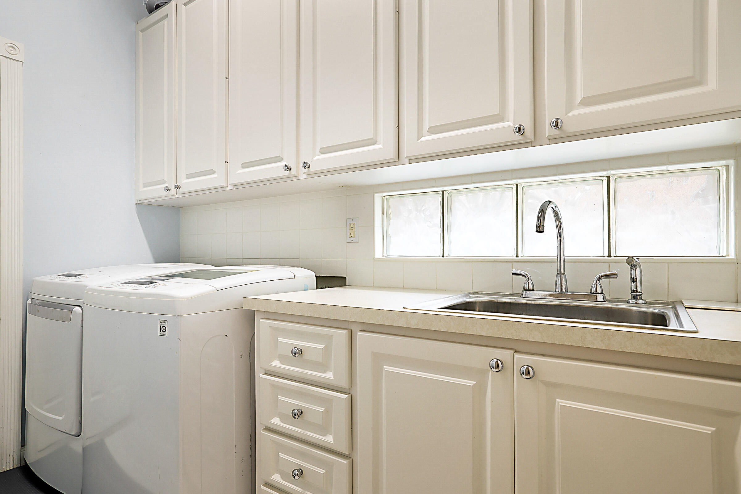 9520 Southwest Wedgewood Lane Stuart, FL 34997 - Photo 34 of 53 a utility room with cabinets washer and dryer