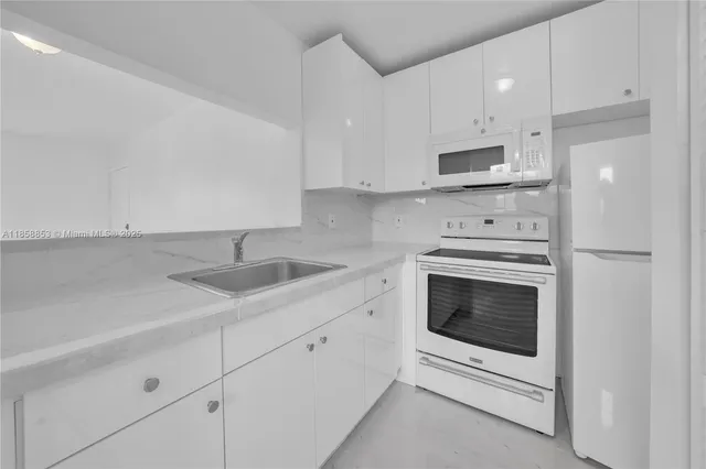 a kitchen with cabinets stainless steel appliances and sink