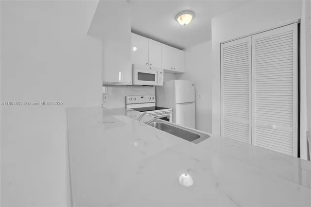 a view of a kitchen with a sink and cabinets