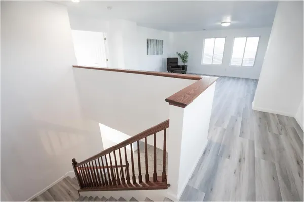 a view of a hallway with wooden floor and staircase
