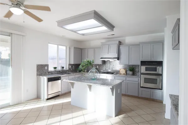 a kitchen with stainless steel appliances granite countertop a sink and a stove