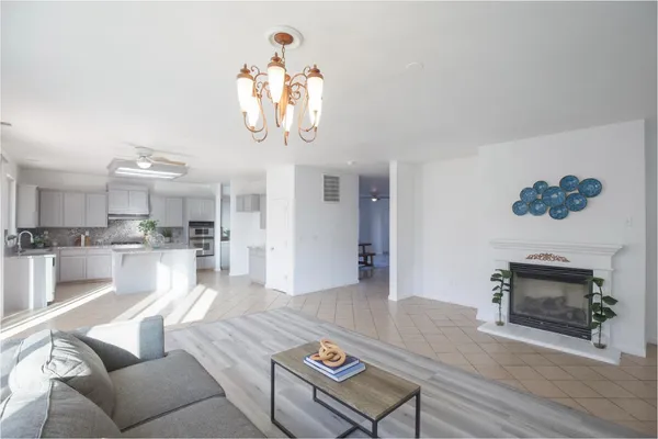 a living room with furniture a chandelier and a fireplace