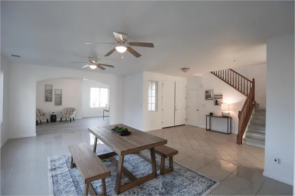 a living room with furniture a dining table and a chandelier
