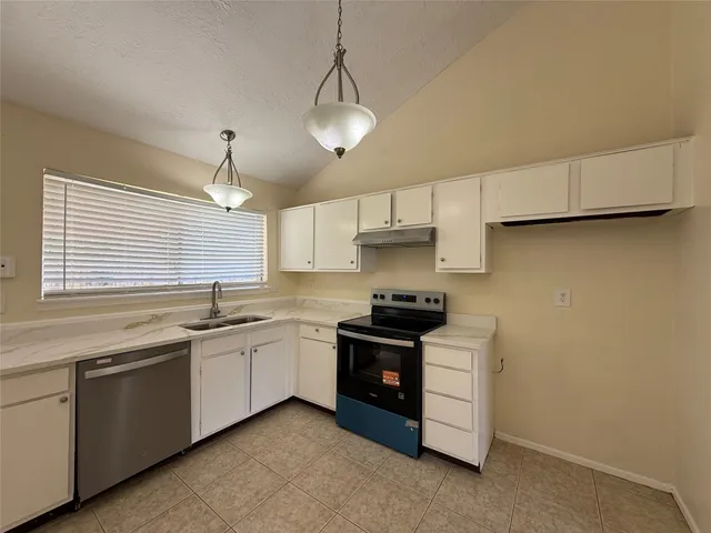 a kitchen with stainless steel appliances a sink stove and cabinets