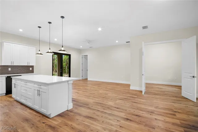a kitchen with stainless steel appliances granite countertop a sink a stove and a wooden floors