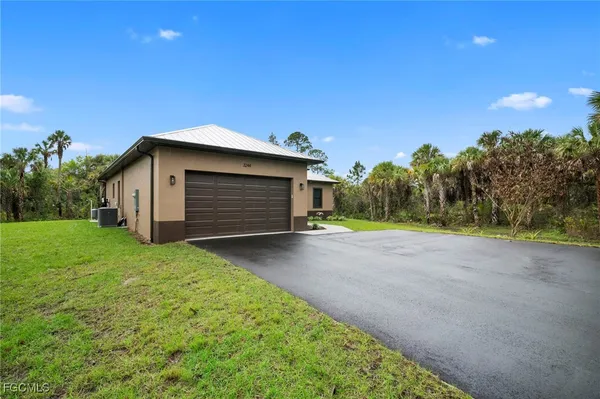 a view of backyard of house and trees with green space