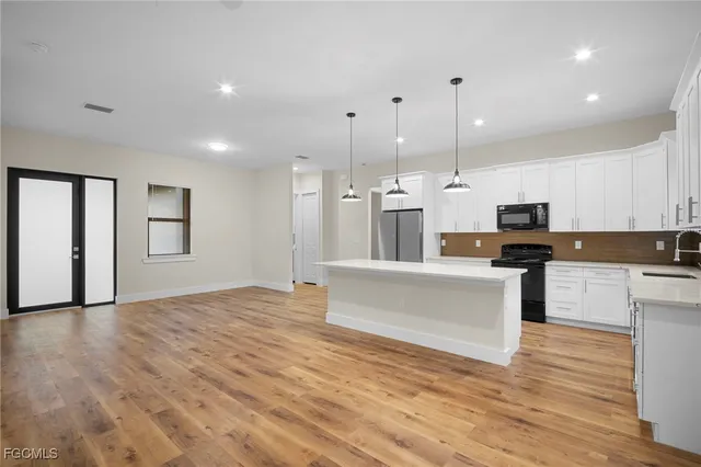 a view of kitchen with cabinets appliances and wooden floor