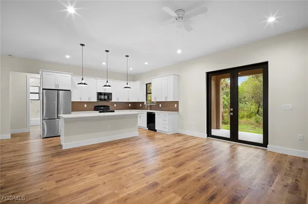 a view of kitchen with stainless steel appliances refrigerator oven and cabinets