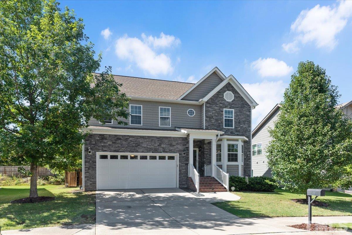 a front view of a house with a yard and garage