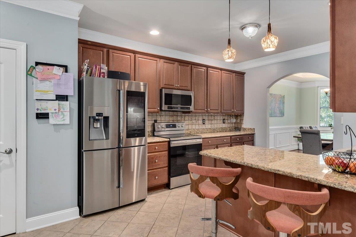 6 Piccadilly Court Durham, NC 27713 - Photo 5 of 27 a kitchen with stainless steel appliances granite countertop a refrigerator a stove a sink a dining table and chairs with wooden floor
