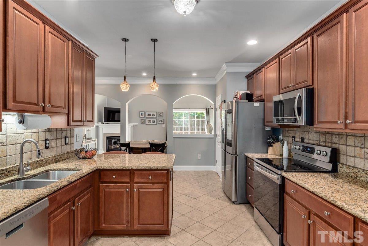 6 Piccadilly Court Durham, NC 27713 - Photo 6 of 27 a kitchen with stainless steel appliances granite countertop a sink a stove a refrigerator cabinets and a kitchen island