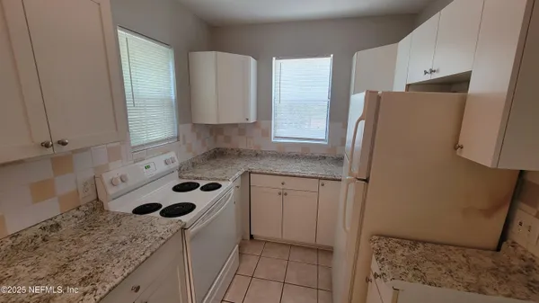 a kitchen with a sink a refrigerator and cabinets