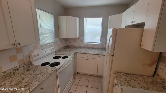 a kitchen with a sink a refrigerator and cabinets