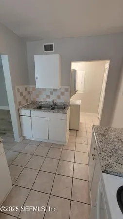 a kitchen with a sink a stove and cabinets
