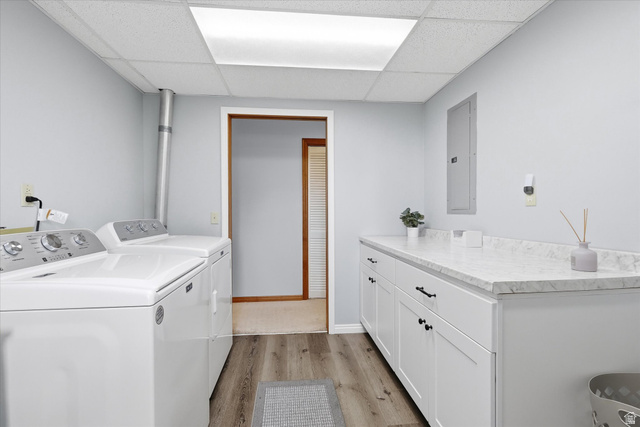 45 West 100 South Mendon, UT 84325 - Photo 33 of 64 Laundry room featuring light wood-style floors, electric panel, separate washer and dryer, a paneled ceiling, and cabinet space