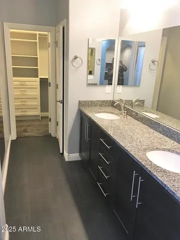 a bathroom with a granite countertop sink and a mirror