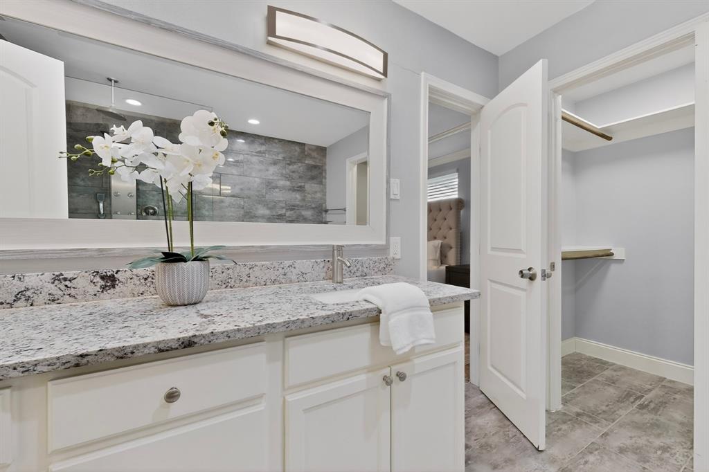 7631 Meadow Road Dallas, TX 75230 - Photo 19 of 40 A bright, elegant primary bathroom showcasing a walk-in closet
