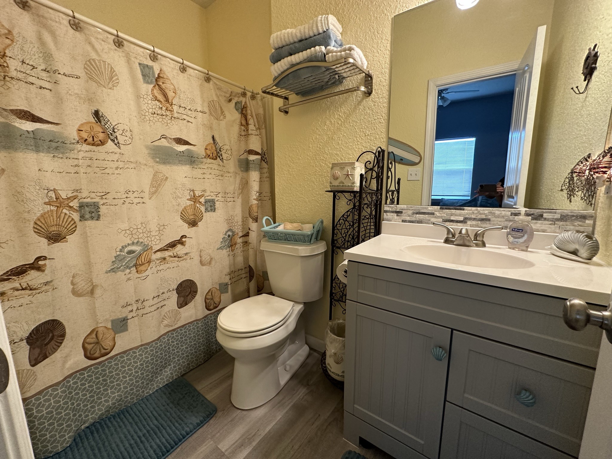 124 Howard Avenue, Unit D Surfside Beach, TX 77541 - Photo 31 of 50 a bathroom with a sink a toilet and shower curtain
