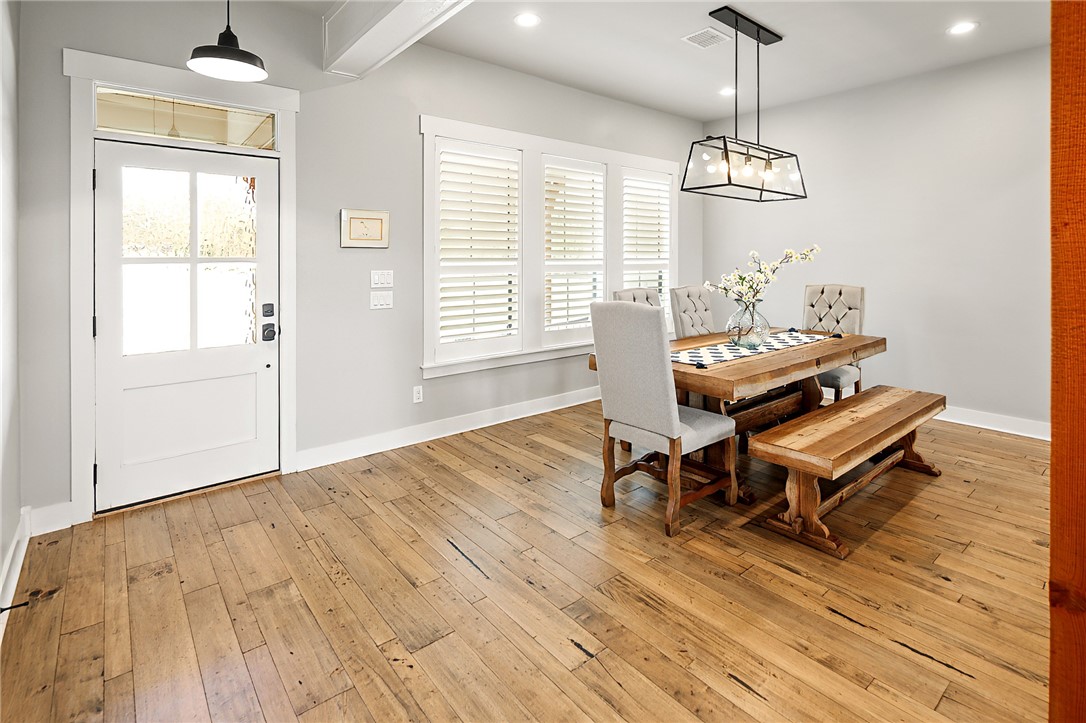 7323 River Ridge Drive College Station, TX 77845 - Photo 10 of 39 a dining room with wooden floor a chandelier a wooden table and chairs