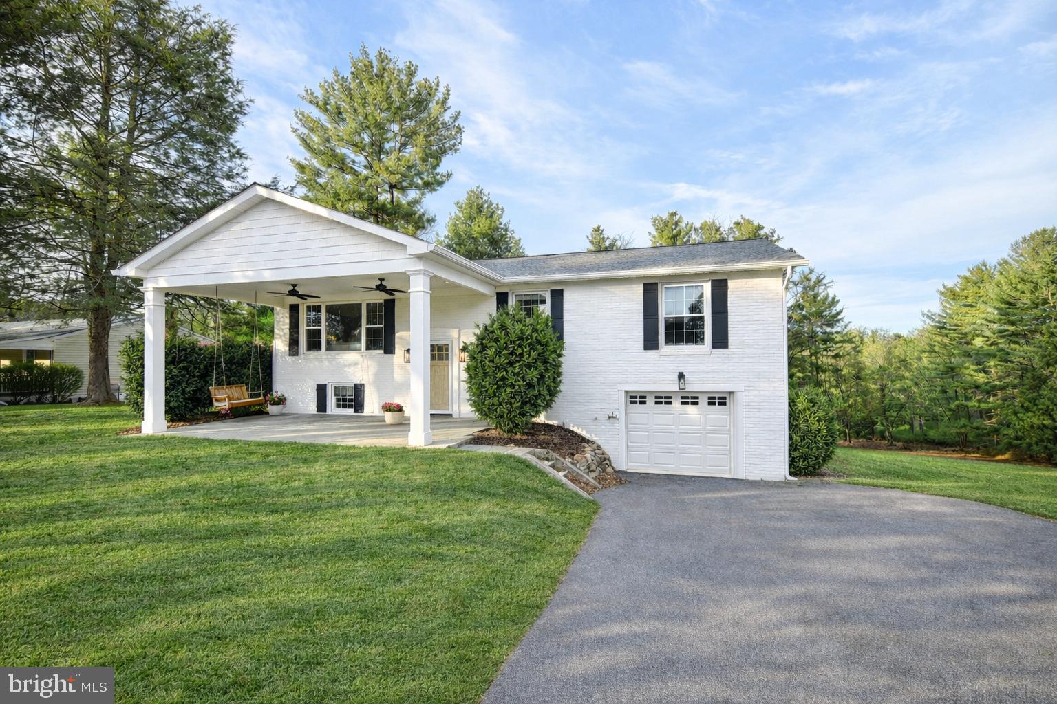 a front view of a house with a yard and green space