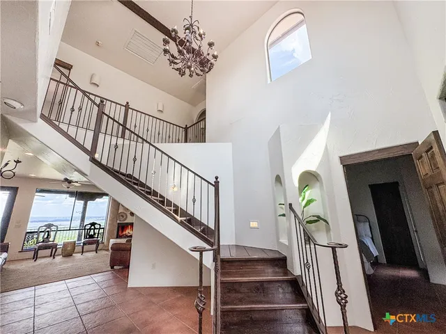 a living room with furniture a large window and a chandelier
