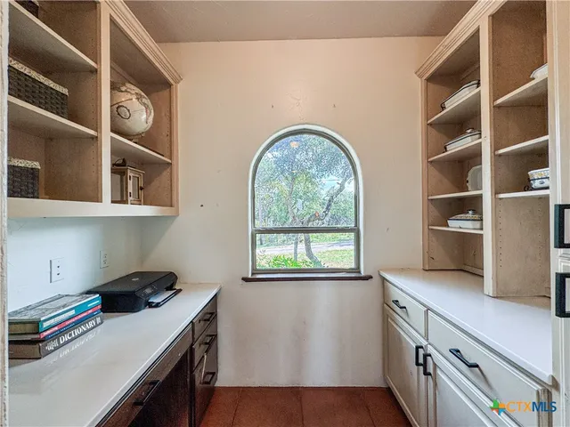a bedroom with a bed next to a window and a chandelier