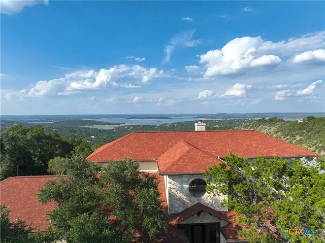 a kitchen with stainless steel appliances kitchen island granite countertop a table chairs in it and wooden floors