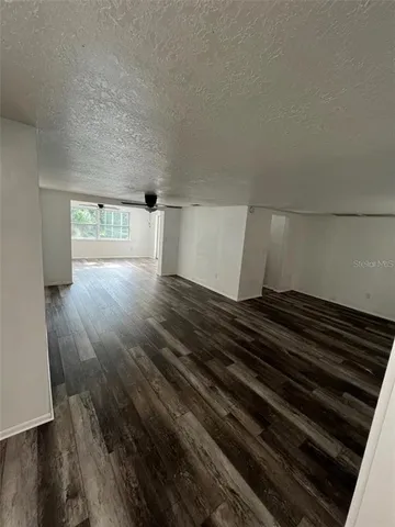 a view of an empty room and wooden floor