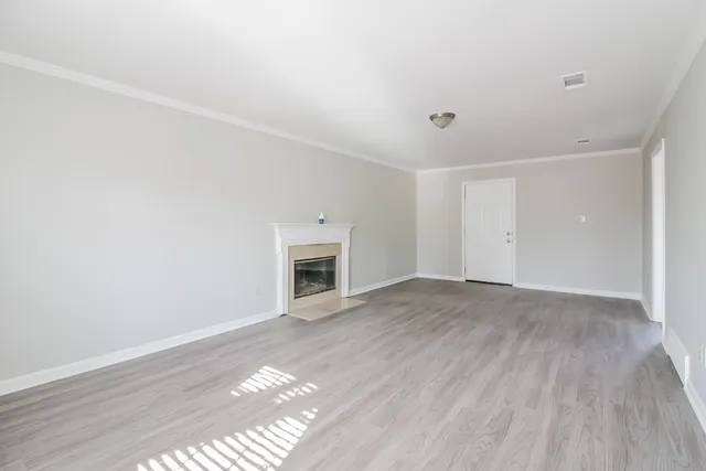 a view of empty room with wooden floor and fireplace
