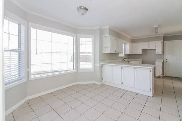 a view of a kitchen with white cabinets