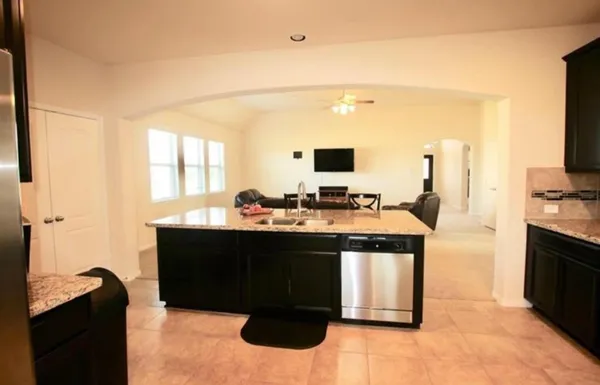 a kitchen with a sink and a stove top oven with wooden floor