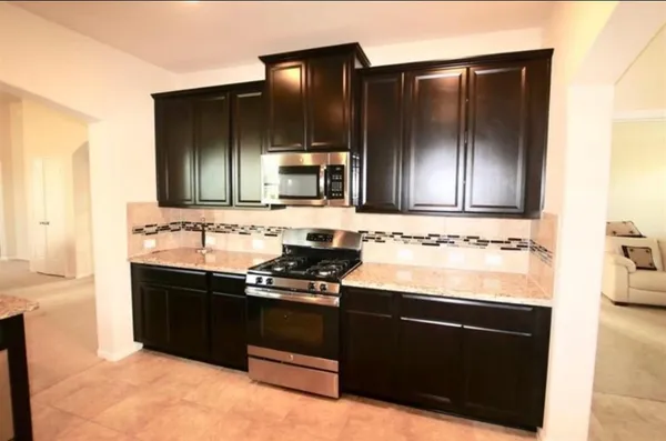 a kitchen with stainless steel appliances wooden cabinets and a sink