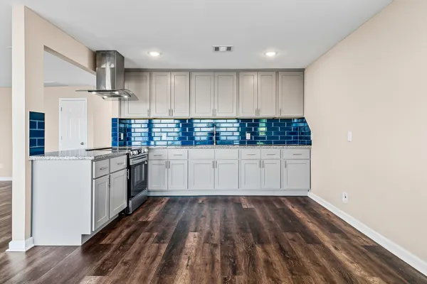 a kitchen with granite countertop white cabinets and white appliances