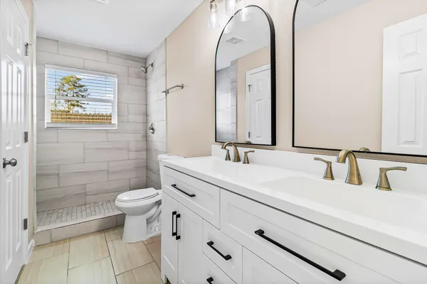 a bathroom with a sink a toilet and shower